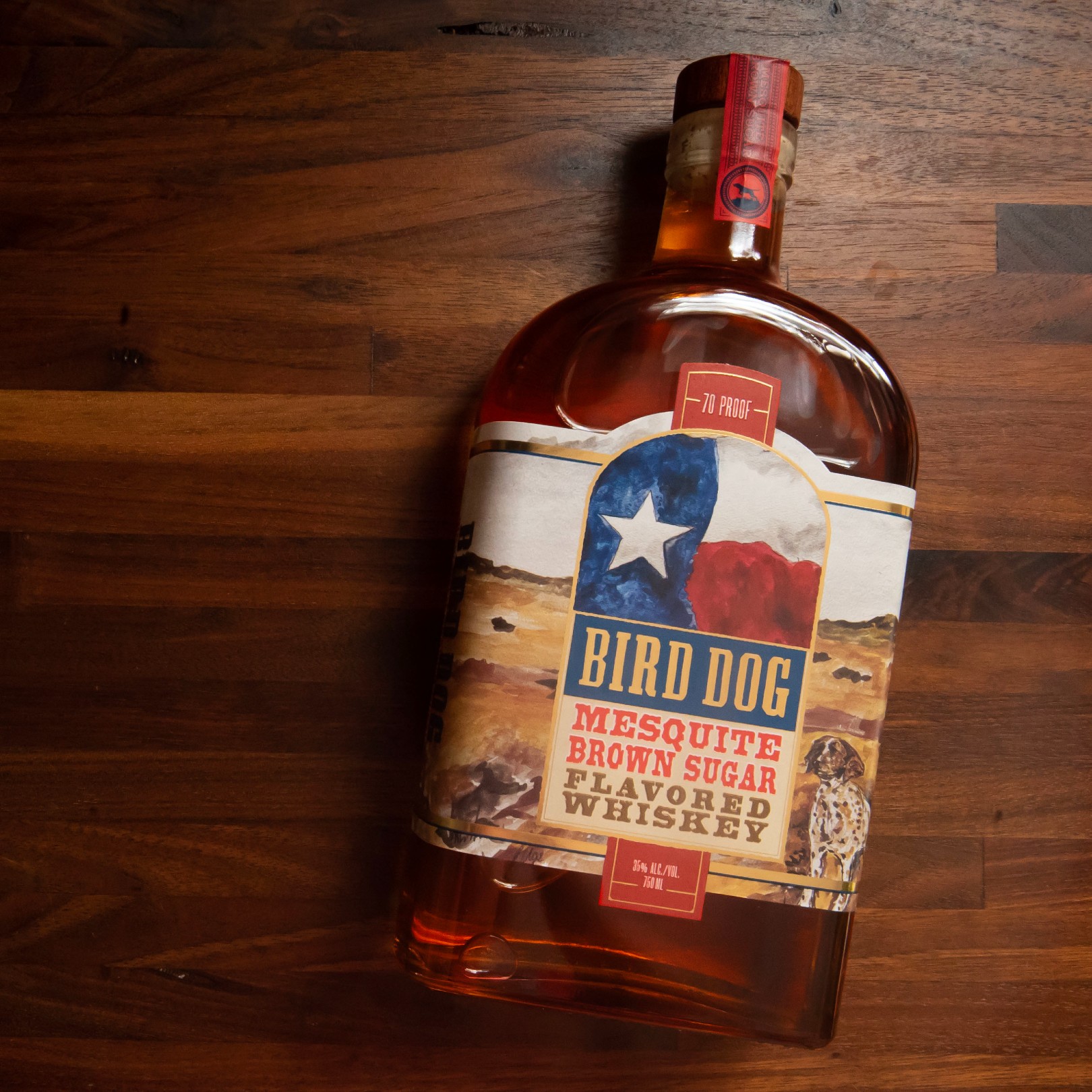 Bottle of Bird Dog Mesquite Brown Sugar laying on wood background